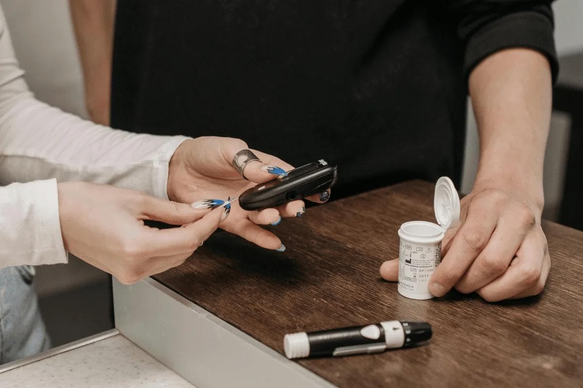 Person inserting test strip into blood glucose meter.